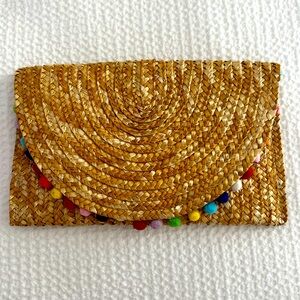 Hand woven clutch with colorful pom-pom details
